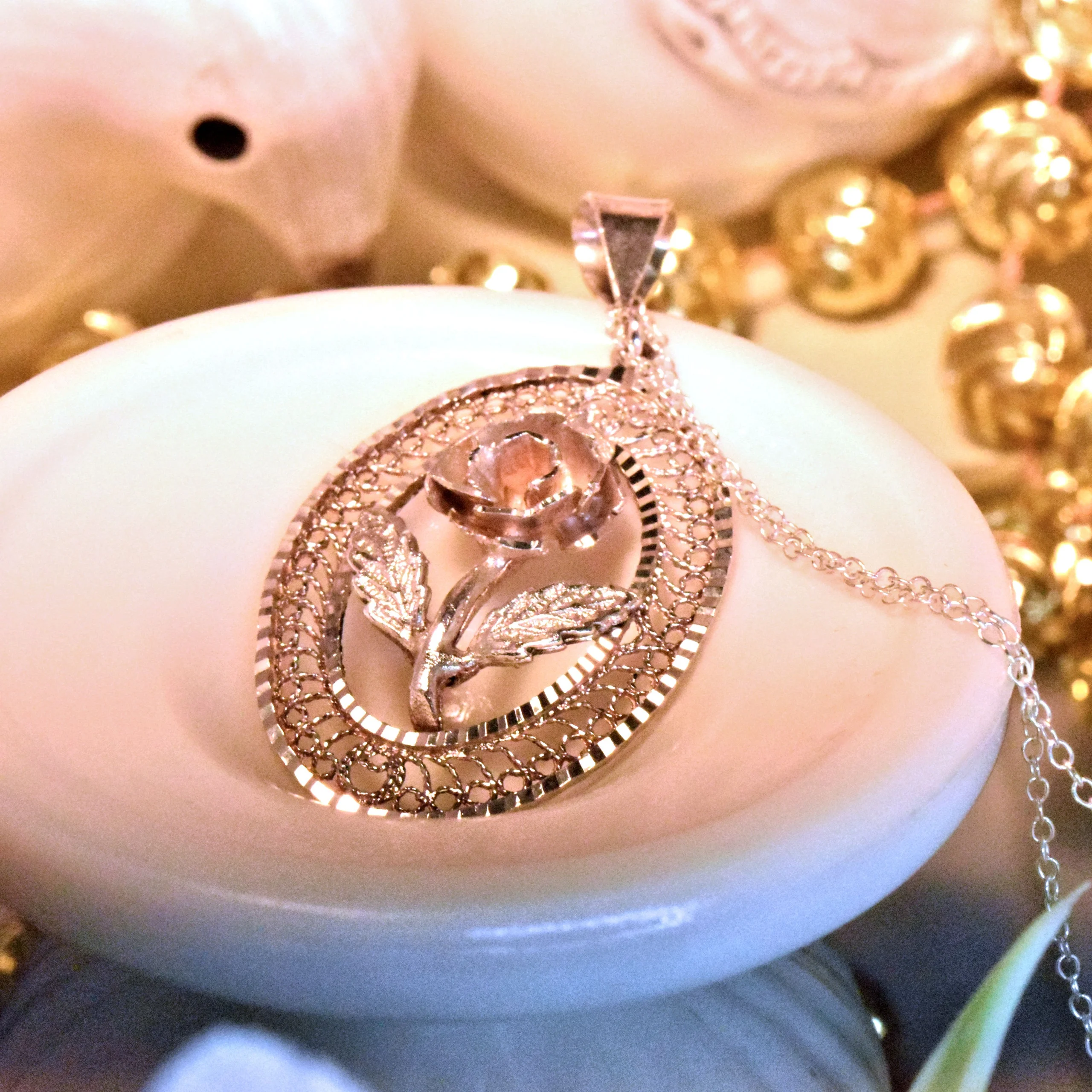 A vintage pendant necklace with a flower on the face of it